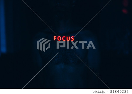 Young man with letters ad Focus word on his face in the dark. Young man with letters ad Focus word on his face in the dark. 81349282