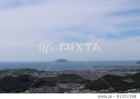 高台から見た低い緑の山と街と丸い島のある青い海と薄雲と青空の見える風景 高台から見た低い緑の山と街と丸い島のある青い海と薄雲と青空の見える風景 81351598