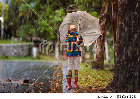 Child playing in autumn rain. Kid with umbrella. Child playing in autumn rain. Kid with umbrella. 81353159