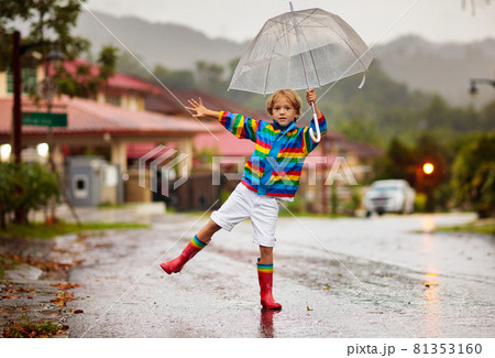 Child playing in autumn rain. Kid with umbrella. Child playing in autumn rain. Kid with umbrella. 81353160