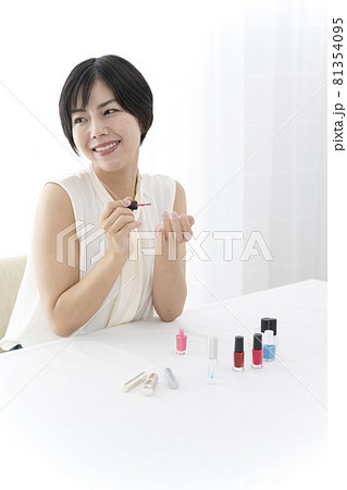 窓ぎわの机でメイクをする女性　ビューティー　スキンケア 81354095