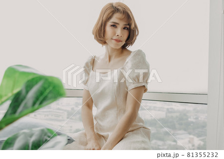 Soft and sweet looking Asian woman wears white dress. 81355232