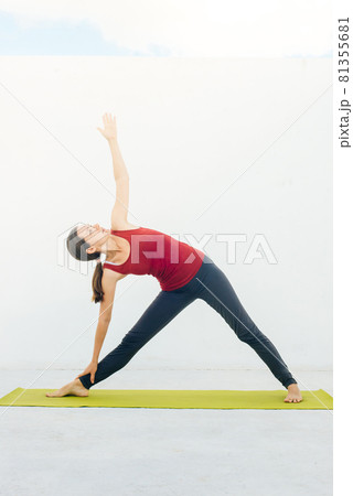 Side view portrait of beautiful young woman doing yoga or pilates exercise on white background 81355681
