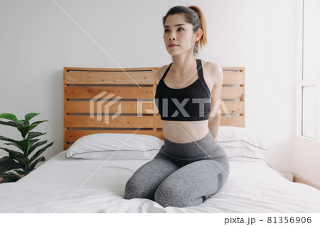 Woman stretching and cool down after workout in her apartment room. Woman stretching and cool down after workout in her apartment room. 81356906
