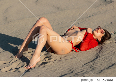 Feminine young sexy woman relaxing on sandy shore 81357888