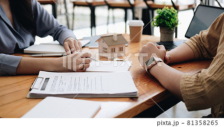 Real estate agent or bank officer describes the loan interest to the customer with home purchase contracts or on office loans and interest rates Real estate agent or bank officer describes the loan interest to the customer with home purchase contracts or on office loans and interest rates 81358265