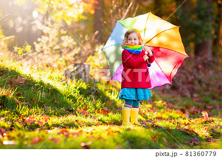 Kid with umbrella playing in autumn rain. Kid with umbrella playing in autumn rain. 81360779