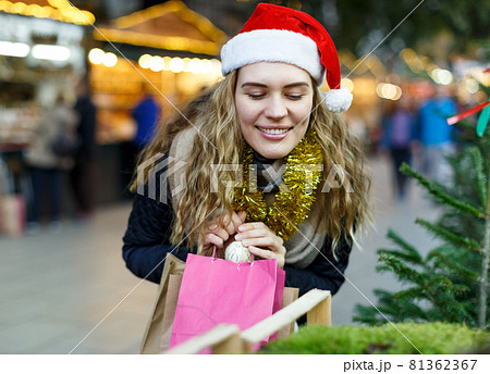 Woman holding bags with Christmas toys 81362367