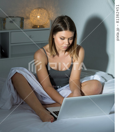 Portrait of sexy positive woman sitting with laptop in bed Portrait of sexy positive woman sitting with laptop in bed 81362451