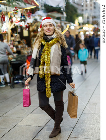 Girl holding paper bags at Christmas fair Girl holding paper bags at Christmas fair 81362622