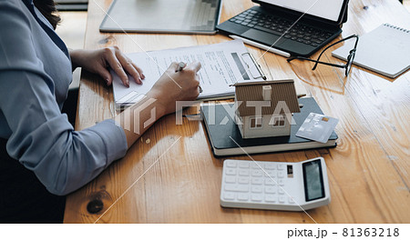 Real estate agent working sign agreement document contract for home loan insurance approving purchases for client with house model and key on wooden desk Real estate agent working sign agreement document contract for home loan insurance approving purchases for client with house model and key on wooden desk 81363218