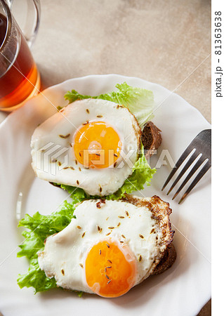 Toasts with fried eggs near hot tea 81363638