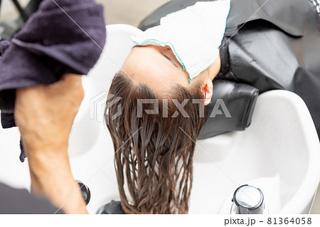 ヘアサロンでシャンプーをしてもらう若い女性 ヘアサロンでシャンプーをしてもらう若い女性 81364058
