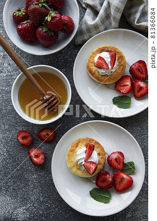 Cottage cheese pancakes, ricotta fritters on ceramic plate with fresh strawberry. Cottage cheese pancakes, ricotta fritters on ceramic plate with fresh strawberry. 81366084