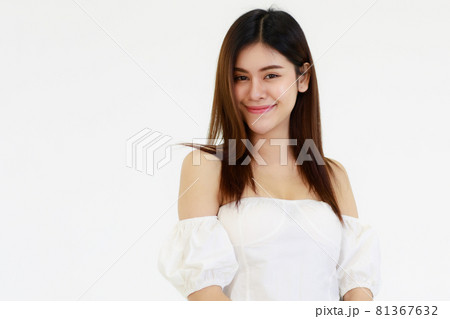 Portrait An Asian adult woman looks teenage-style with her long hair and black color smiling standing and looking at a camera. A woman wears a white shirt and blue jean with white background in a Portrait An Asian adult woman looks teenage-style with her long hair and black color smiling standing and looking at a camera. A woman wears a white shirt and blue jean with white background in a 81367632