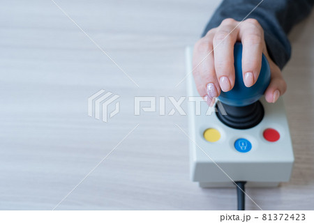 Woman with cerebral palsy works on a specialized computer mouse. Woman with cerebral palsy works on a specialized computer mouse. 81372423