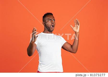 Portrait of African young man in casual clothes isolated on red color studio background. Concept of human emotions, facial expression, youth, feelings, ad. Portrait of African young man in casual clothes isolated on red color studio background. Concept of human emotions, facial expression, youth, feelings, ad. 81373277