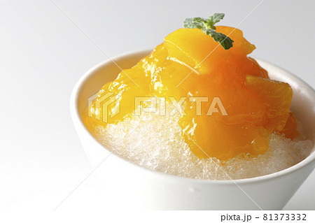果肉入りのマンゴーシロップがたっぷりとかかったかき氷を白背景で撮影 果肉入りのマンゴーシロップがたっぷりとかかったかき氷を白背景で撮影 81373332