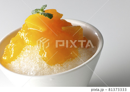 果肉入りのマンゴーシロップがたっぷりとかかったかき氷を白背景で撮影 果肉入りのマンゴーシロップがたっぷりとかかったかき氷を白背景で撮影 81373333