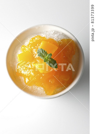 果肉入りのマンゴーシロップがたっぷりとかかったかき氷を白背景で俯瞰撮影 果肉入りのマンゴーシロップがたっぷりとかかったかき氷を白背景で俯瞰撮影 81373399