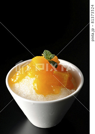 果肉入りのマンゴーシロップがたっぷりとかかったかき氷を黒背景で撮影 果肉入りのマンゴーシロップがたっぷりとかかったかき氷を黒背景で撮影 81373524