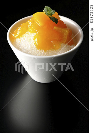 果肉入りのマンゴーシロップがたっぷりとかかったかき氷を黒背景で撮影 果肉入りのマンゴーシロップがたっぷりとかかったかき氷を黒背景で撮影 81373525