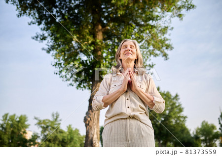 Smiling woman holding palms in front of her 81373559