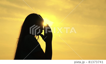 A Muslim girl prays in the glare of the sun in the sky, a little teenager believes in goodness, ask for forgiveness from heaven, educate a kid in religion, ask for good things in life, child dream of 81373741