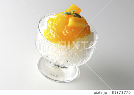 果肉入りのマンゴーシロップがたっぷりとかかったかき氷を白背景で撮影 81373770