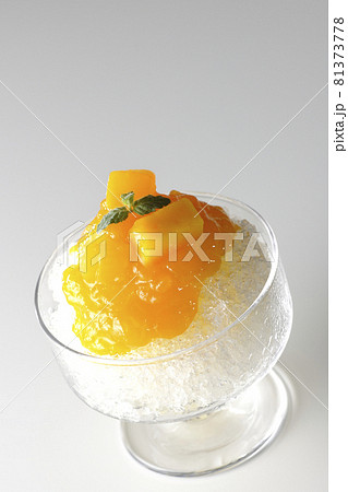 果肉入りのマンゴーシロップがたっぷりとかかったかき氷を白背景で撮影 果肉入りのマンゴーシロップがたっぷりとかかったかき氷を白背景で撮影 81373778