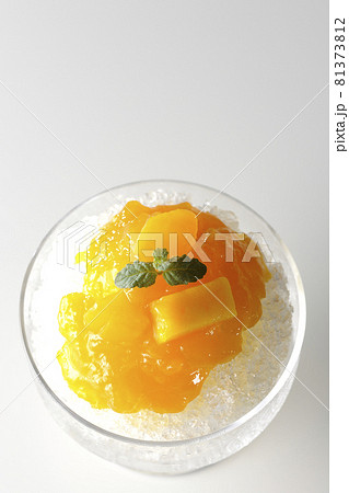 果肉入りのマンゴーシロップがたっぷりとかかったかき氷を白背景で俯瞰撮影 81373812
