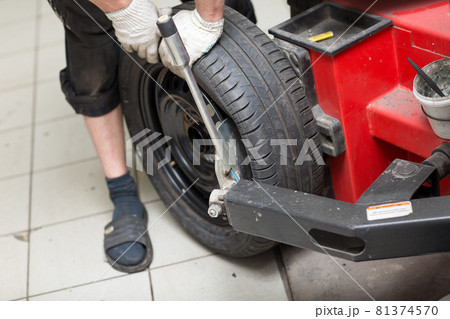Mechanic changing car tire fitting. Wheel tyre repairing. Mechanic changing car tire fitting. Wheel tyre repairing. 81374570