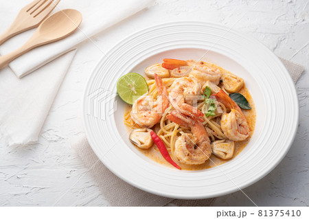 Stir fried Spaghetti with Shrimp,squid and straw mushroom in tom yum sauce.Thai fusion food 81375410