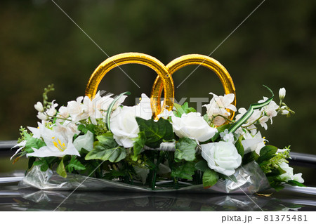 wedding rings on the car with bunch of flowers 81375481
