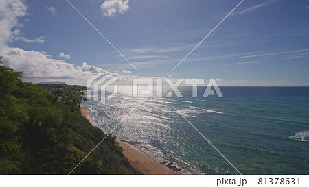 View from above to Diamond Head Beach Park. People swim in the ocean. Yellow sand on the beach on the tropical island of Oahu Hawaii. The turquoise color of the Pacific Ocean water. 81378631
