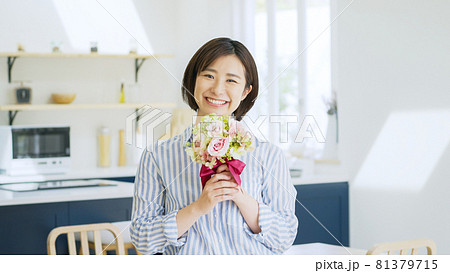 リビングで花束を持つ若い女性 リビングで花束を持つ若い女性 81379715