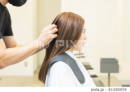 ヘアサロンで女性の髪の毛をカットするスタイリストの手元 81380956