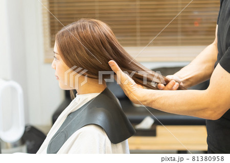 ヘアサロンで女性の髪の毛をカットするスタイリストの手元 ヘアサロンで女性の髪の毛をカットするスタイリストの手元 81380958