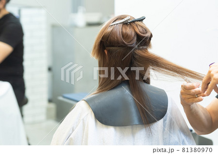 ヘアサロンで女性の髪の毛をカットするスタイリストの手元 ヘアサロンで女性の髪の毛をカットするスタイリストの手元 81380970