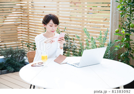 屋外でワーケーション中にスマホを操作する女性 屋外でワーケーション中にスマホを操作する女性 81383092