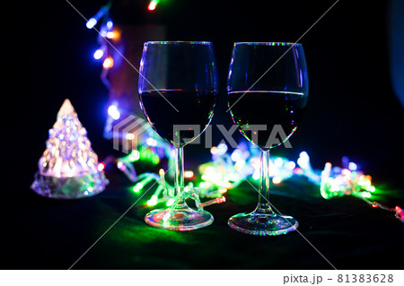 two wine glasses in a shining garland with a toy christmas tree two wine glasses in a shining garland with a toy christmas tree 81383628