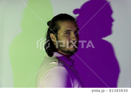 side view of a latino and bearded gay young man in studio 81383630