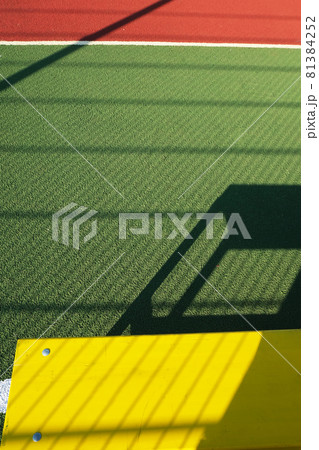 Outdoor sport playground with rubberized ground. Yellow bench on a green sport field. Physical Culture school lesson. Sport background for poster, wallpaper or banner Outdoor sport playground with rubberized ground. Yellow bench on a green sport field. Physical Culture school lesson. Sport background for poster, wallpaper or banner 81384252