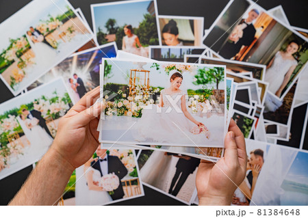 hands lay out wedding photos. the result of the photographer's work at wedding. 81384648