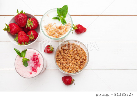 Healthy breakfast with yoghurt, granola and strawberries on white wooden background top view 81385527