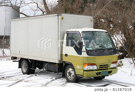雪の駐車場に止めてある2トン積みのパネルバントラック 81387019