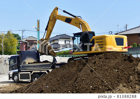 ダンプカーへ土砂積み込み作業を行う油圧ショベルの写真素材 [81388288] - PIXTA