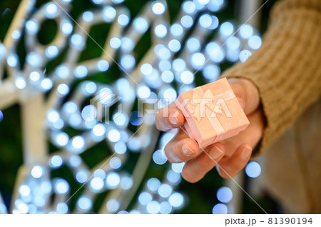 Cropped shot of someone hand with a small pink wrapped gift box. Gift or present is an item given to someone without the expectation of payment or anything in return. Cropped shot of someone hand with a small pink wrapped gift box. Gift or present is an item given to someone without the expectation of payment or anything in return. 81390194
