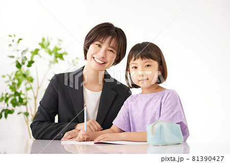 小学生に勉強を教える若い女性 81390427