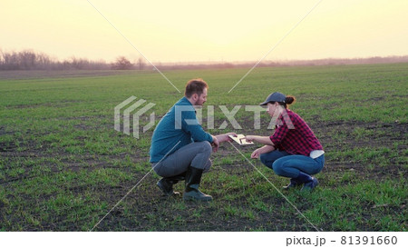 Farmers teaming up to make a business plan in the tablet in the field, the concept of rural life, agricultural work on fertilization with organic substances of the farm, senior agronomist 81391660